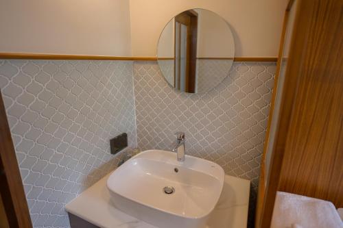 a bathroom with a white sink and a mirror at Ploen Pirom in Lat Krabang