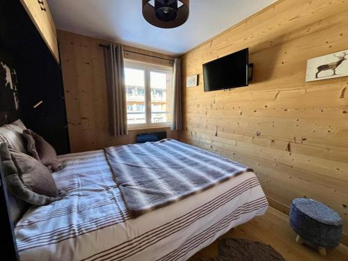 une chambre avec un lit et une télévision sur un mur dans l'établissement Bel Alp, cosy au pied des pistes, à Les Deux Alpes