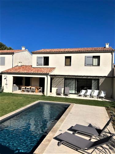 une maison avec une piscine et deux chaises longues dans l'établissement Malaucène Villa Mont Serein, à Malaucène