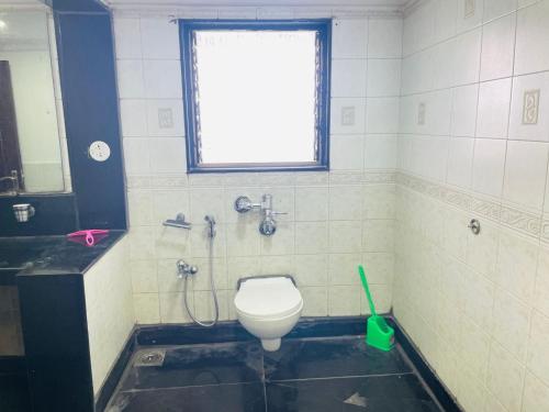 a bathroom with a toilet and a sink and a window at Hostel Lifespace- Tailor made for working professionals- Luxurious Twin Bungalow with CoWork- only 3 and 4 share Rooms in Pune