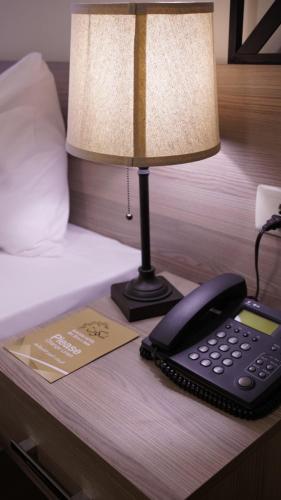 a telephone sitting on a table next to a bed at Sukoon Hotel Amman in Amman