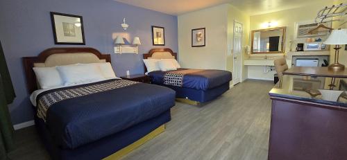 a hotel room with two beds and a desk at Rodeway Inn & Suites Blythe I-10 in Blythe