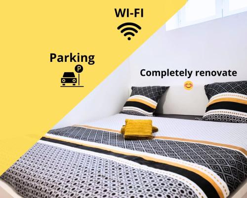 - une chambre avec un lit et un mur jaune dans l'établissement Start appart, à Village-Neuf