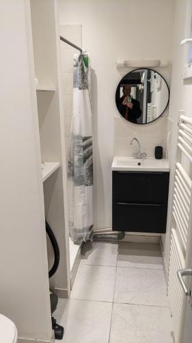 une salle de bain avec un lavabo et un miroir dans l'établissement L'échappée, au Havre