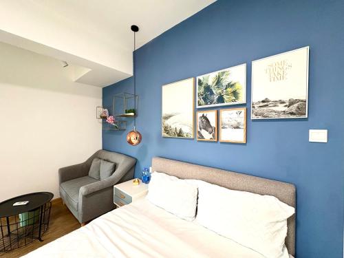 a bedroom with a blue wall with a bed and a chair at 深圳LaCave公寓 in Shenzhen
