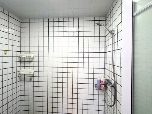 a white tiled bathroom with a shower stall at 深圳LaCave公寓 in Shenzhen