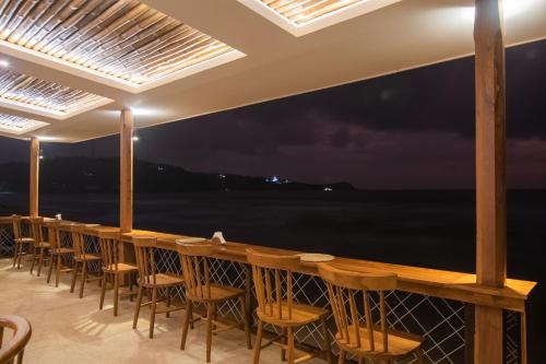 a bar with chairs and a view of the ocean at Azuri Bay in Galle