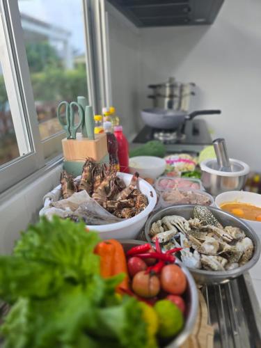 a table with many bowls of vegetables on a counter at เดอรำพึง De Ramphueng ชายหาดแม่รำพึง ระยอง in Ban Chak Phai