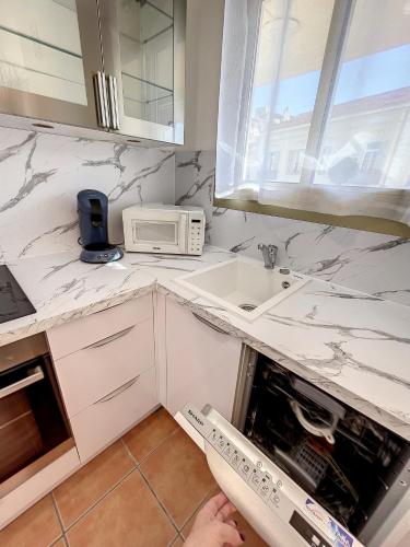 une cuisine avec un évier et un micro-ondes dans l'établissement A 2 pas des plages et centre 324L TER, à Cannes