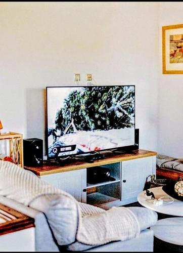 a living room with a flat screen tv on a entertainment center at Villa Pialia in Piáleia