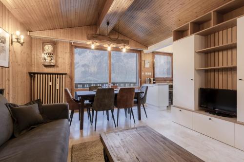 une cuisine et une salle à manger avec une table et des chaises dans l'établissement Appt Laltimetre - Jardin - Skis aux pieds, à Chamonix-Mont-Blanc