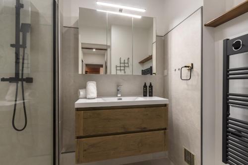 une salle de bain avec un lavabo et une douche dans l'établissement Appt Laltimetre - Jardin - Skis aux pieds, à Chamonix-Mont-Blanc