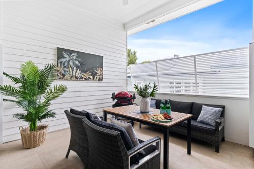 a patio with a wooden table and chairs and a table at Stylish 3BR Townhouse CampHill - WiFi, Parking in Brisbane