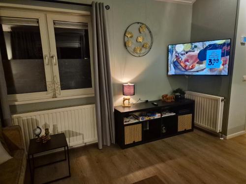 a living room with a flat screen tv on the wall at vakantiehuis in zeeland in Sint Annaland