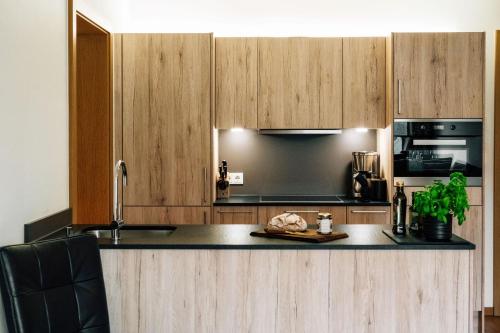 a kitchen with wooden cabinets and a black counter top at Kühtai Alpensuites in Kühtai