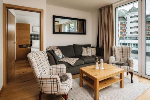 a living room with a couch and two chairs and a table at Kühtai Alpensuites in Kühtai