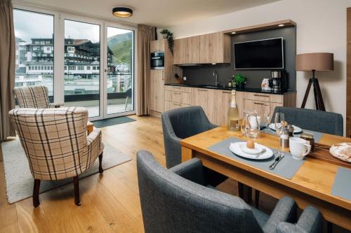a living room with a dining room table and chairs at Kühtai Alpensuites in Kühtai