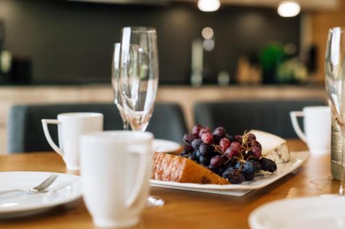 a table with a plate of food and wine glasses at Kühtai Alpensuites in Kühtai