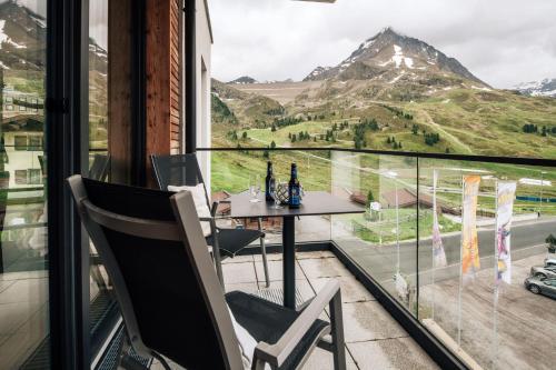 a balcony with a table and chairs and a view of a mountain at Kühtai Alpensuites in Kühtai