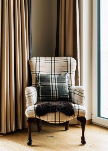 a chair with a pillow in a room with curtains at Kühtai Alpensuites in Kühtai