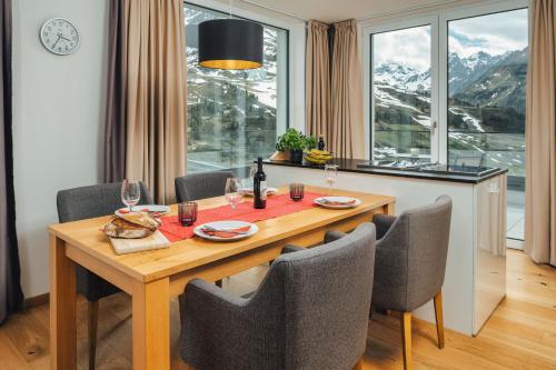 a dining room with a table and chairs and a window at Kühtai Alpensuites in Kühtai
