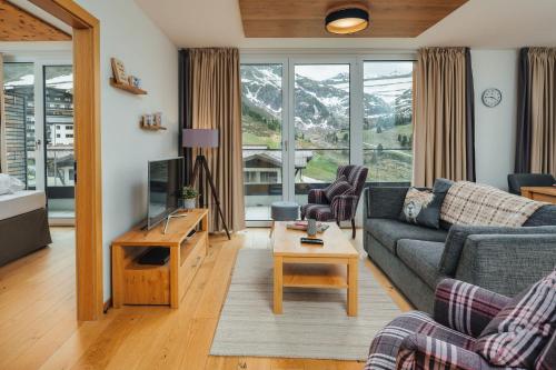 a living room with a couch and a table at Kühtai Alpensuites in Kühtai