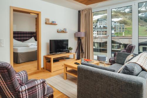 a living room with two chairs and a television at Kühtai Alpensuites in Kühtai