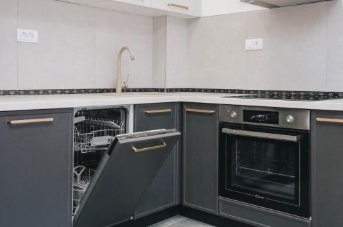 una cucina con elettrodomestici neri e lavastoviglie di Top27 a Budua