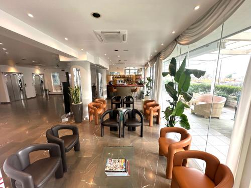 a lobby with chairs and a bar in a building at Club House Hotel in Rimini