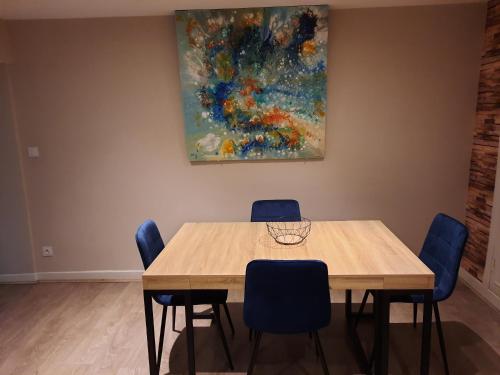 une table et des chaises dans une pièce avec un tableau dans l'établissement L'Azur - Apt 4 Prs avec jardin en centre ville, à Dijon