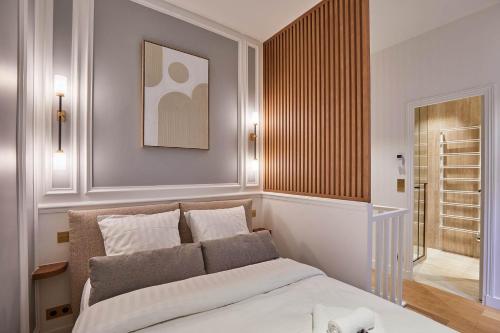 une chambre avec un grand lit avec des draps blancs dans l'établissement Sublim 1BDR AC Arc de Triomphe Champs Elysees by Studio Prestige, à Paris