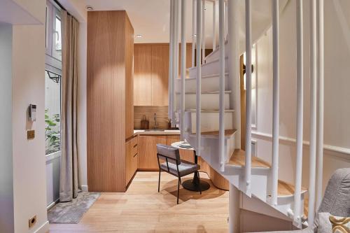un escalier dans une pièce avec une chaise et une cuisine dans l'établissement Sublim 1BDR AC Arc de Triomphe Champs Elysees by Studio Prestige, à Paris