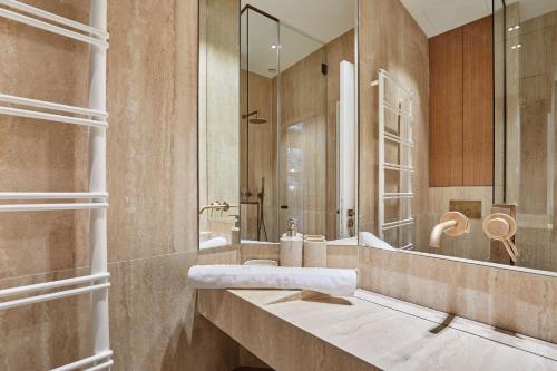 une salle de bain avec un lavabo et un miroir dans l'établissement Sublim 1BDR AC Arc de Triomphe Champs Elysees by Studio Prestige, à Paris