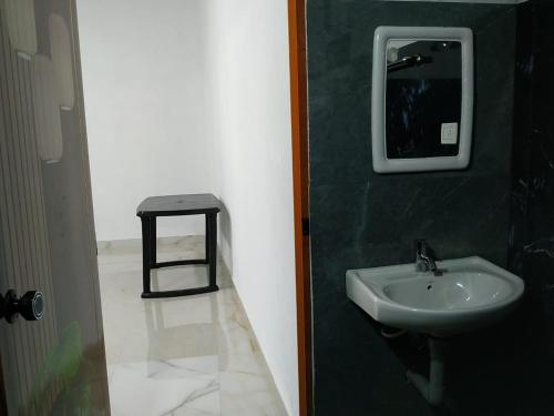 a bathroom with a sink and a mirror and a stool at The Ocean View in Ullāl