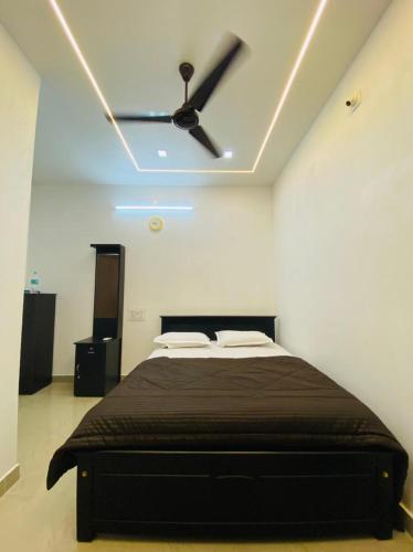 a bedroom with a bed with a ceiling fan at The Ocean View in Ullāl