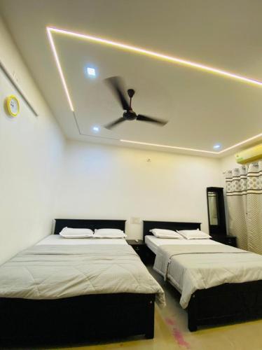 a bedroom with two beds and a ceiling fan at The Ocean View in Ullāl