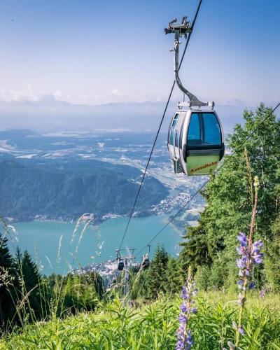 a gondola ride on a mountain with a lake at Ferienwohnung Resi mit traumhaftem Seepanorama in Steindorf am Ossiacher See