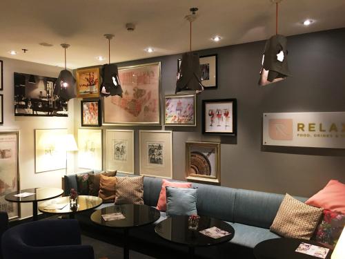 a living room with a couch and two tables at Mercure Hotel & Residenz Berlin Checkpoint Charlie in Berlin