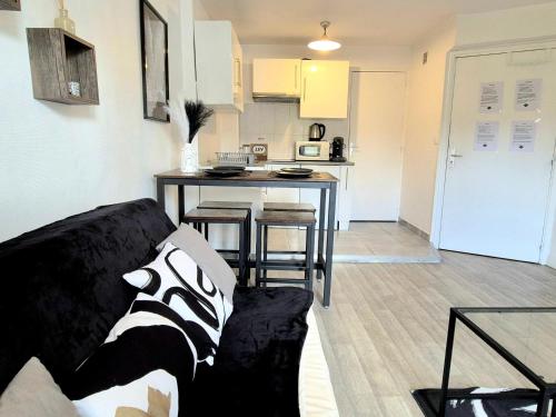 un salon et une cuisine avec un canapé et une table dans l'établissement L'Atelier-T2 proche du centre-Wifi-Parking, à Lourdes