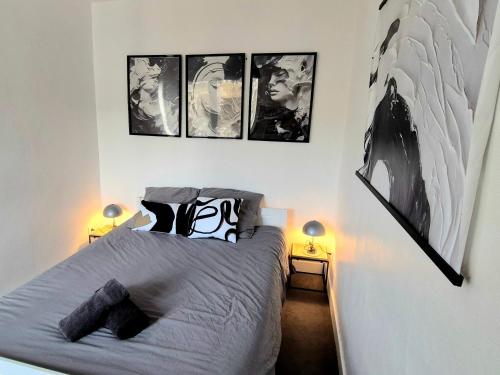 a bedroom with a bed with four pictures on the wall at L'Atelier-T2 proche du centre-Wifi-Parking in Lourdes