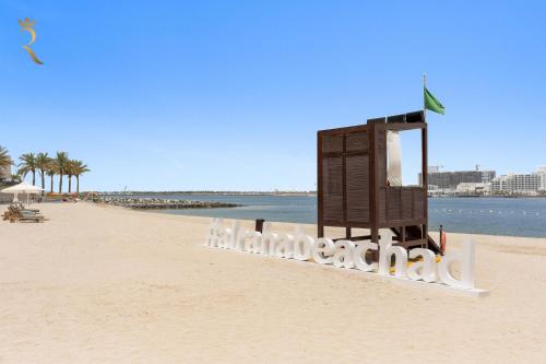 a beach with a sign that reads limbo at Oasis Stylish 2BR in Al Rahba - Modern Stay Near Al Raha Beach & Yas Island in Yas Island