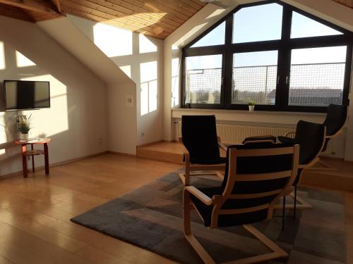 a living room with a table and chairs and windows at Gästewohnung in Parkstetten bei Straubing in Parkstetten