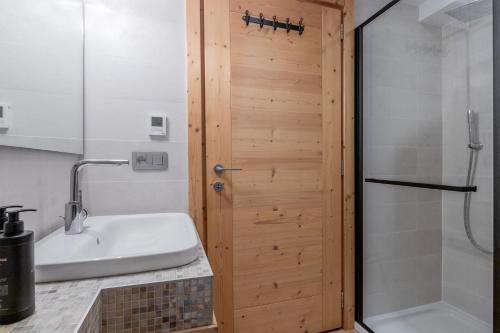 La salle de bains est pourvue d'une douche et d'un lavabo blanc. dans l'établissement Jardin du Brevent, à Chamonix-Mont-Blanc