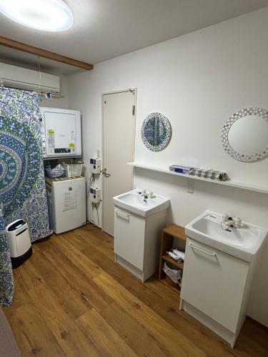 a bathroom with two sinks and a refrigerator at Kanazawa Guesthouse Stella in Kanazawa