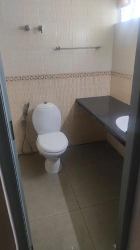 a bathroom with a white toilet and a sink at 3 bhk near lulu mall kochi in Cochin