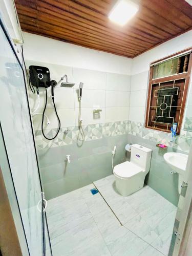 a bathroom with a shower and a toilet and a sink at Ranga's House in Weligama