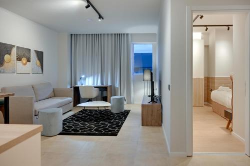 a living room with a couch and a bedroom at Nomads Lux Studios & Business Center in Ioannina