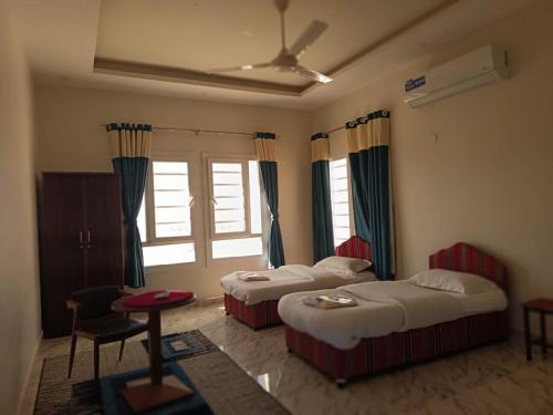a hotel room with two beds and a window at Jabal Shams bayt kawakib in Misfāh