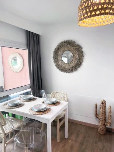 - une table à manger blanche avec des chaises et un miroir dans l'établissement T2 Cosy centre ville, parking privé, à La Grande Motte