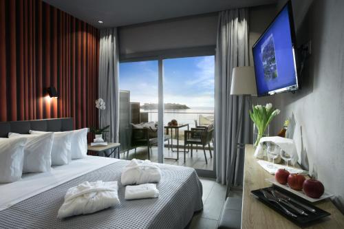 a hotel room with a large bed and a balcony at Akti Toroni Boutique Hotel in Toroni